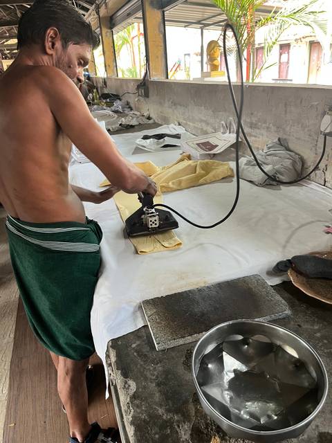      Person using an industrial iron on a table.
  