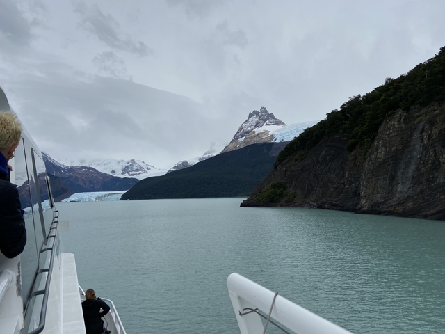 Boat near a glacier with mountainous landscape.