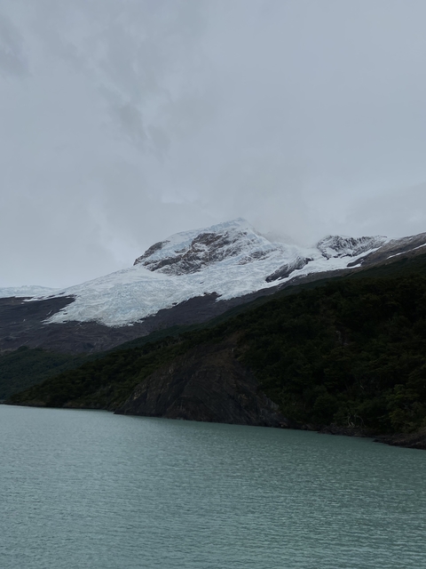       Mountain with snow covering peak and clouds.
  