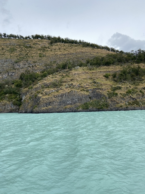       Rocky hill overlooking a body of water.
  