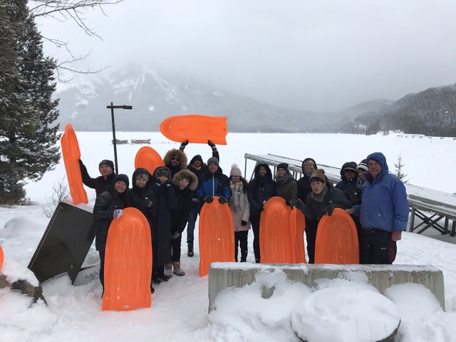       Group of people with sleds in a snowy landscape.
  