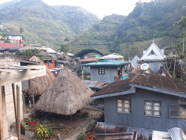 Traditional village houses with mountains behind.
