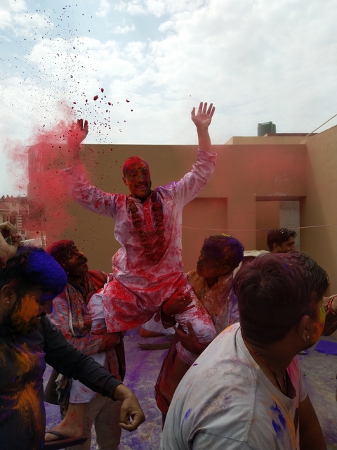       Group celebrating with colored powders during Holi.
  