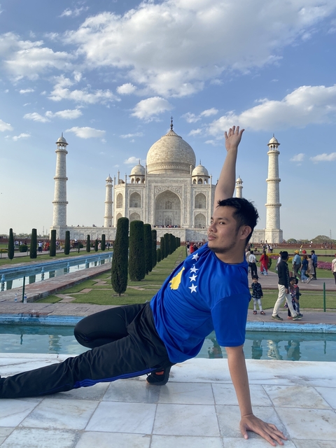Man posing in front of the Taj Mahal.