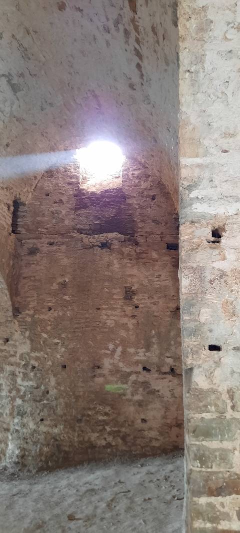       Stone wall with a beam of light entering.
  