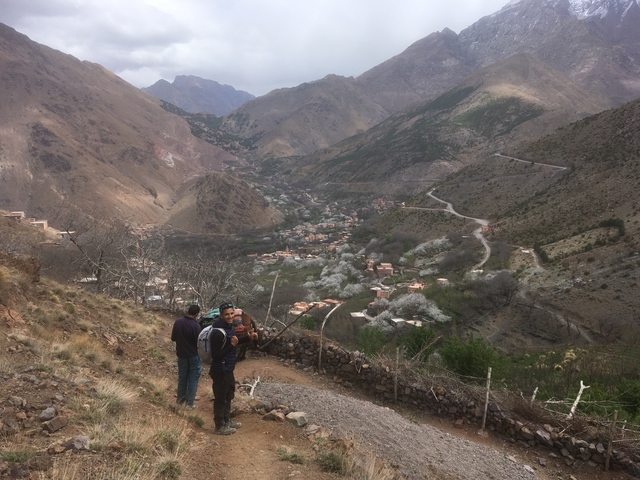 Panoramic view of mountain village surrounded by hills.