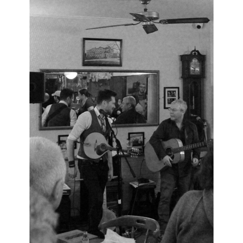 Musicians performing with instruments inside a pub.