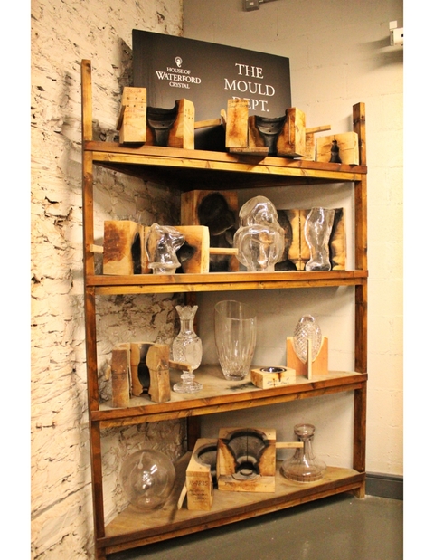 Shelf displaying crystal glassware in a workshop.