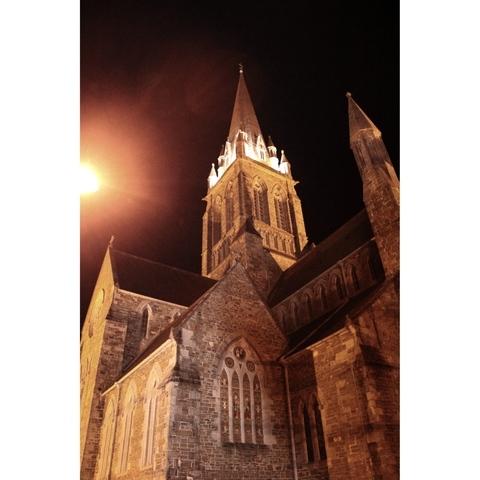 Church tower illuminated at night with architectural details.