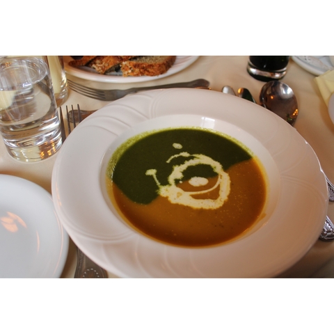 Bowl of soup with a design in the cream on the surface.