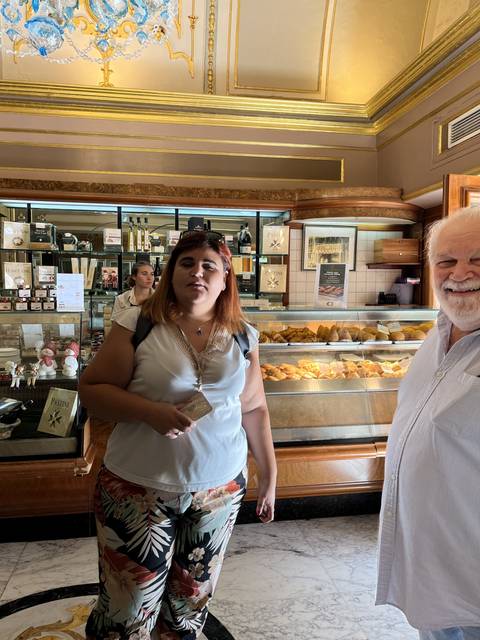 Person standing in front of a bakery display.