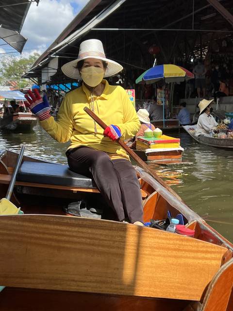 A person in a boat at a floating market.
