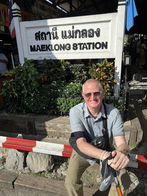 A smiling man at a train station.