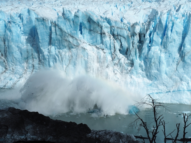       Dramatic calving glacier with ice crashing into the water.
  
