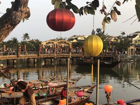       Traditional boats and colorful lanterns on a river.
  
