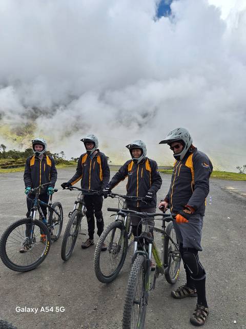 Group standing with bicycles, wearing helmets.