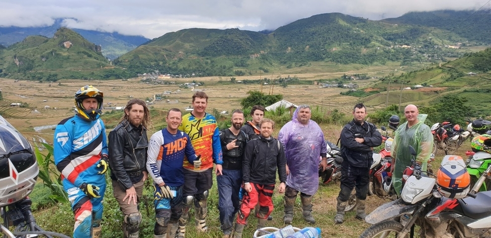 Group of bikers with motorcycles in a mountainous area.