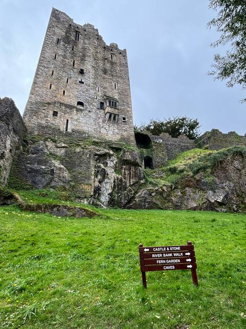 A castle with a sign pointing to various attractions.