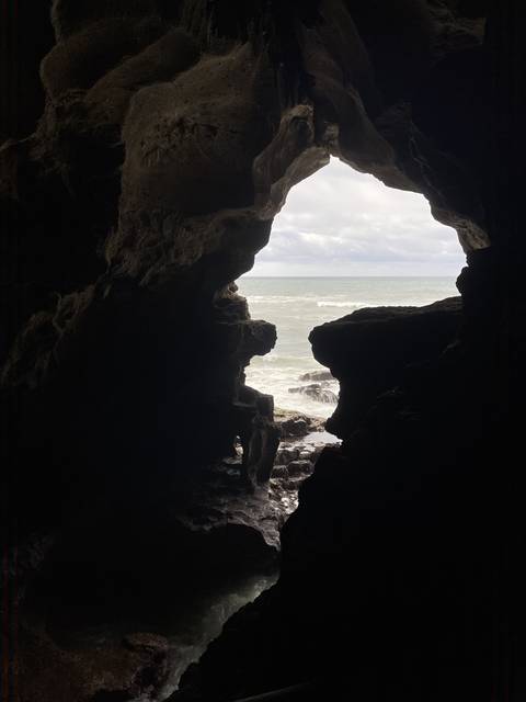 Dark cave with an opening to the ocean.