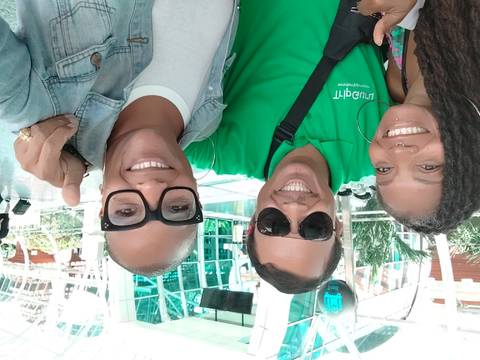 Two people taking a selfie indoors with modern architecture in the background.