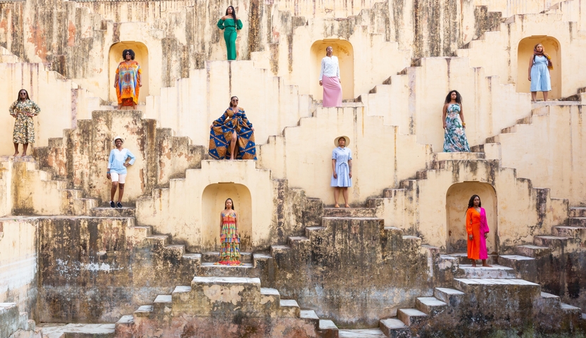 Women in vibrant dresses positioned uniquely on stepwell architecture.