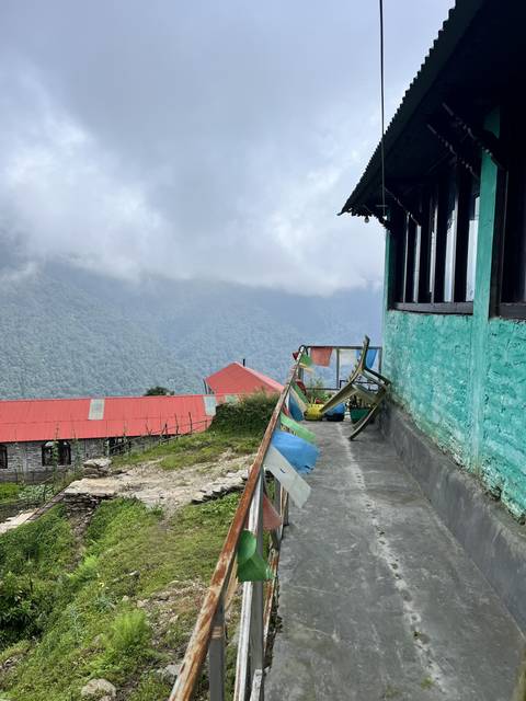       Narrow mountain path with colorful prayer flags.
  