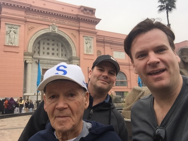       Three men taking a selfie outside an Egyptian museum.
  