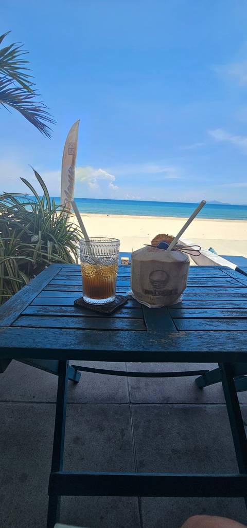       Beverages on a table with a beach view.
  