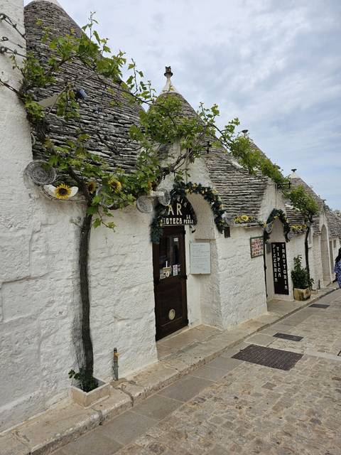 Quaint stone building with floral decorations in an alley.