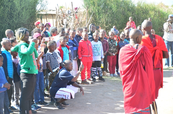 Audience observing traditional ceremony outdoors.