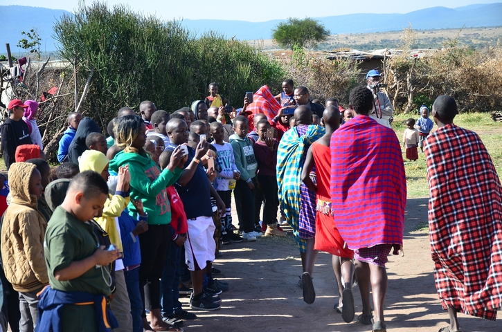People mingling outdoors with some in traditional clothing.