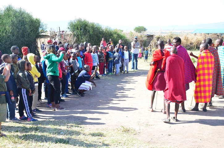 Mixed group of people observing traditional dancers.