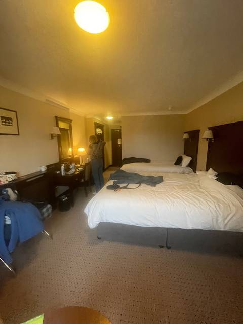 Hotel room with beds and people.