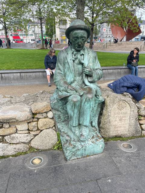 Bronze statue of a man on a bench.