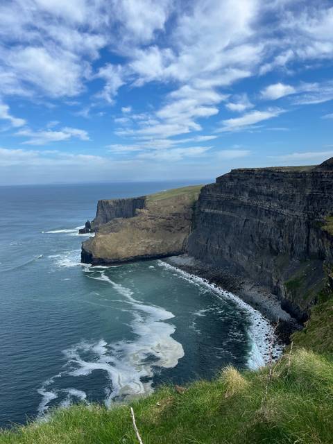       Cliffs overlooking the ocean with waves crashing below.
  