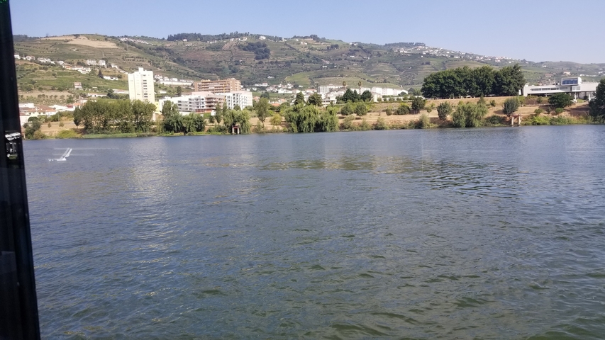 River view with buildings and hills in the background.