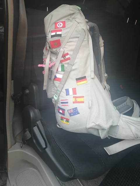 Backpack decorated with various country flag patches.