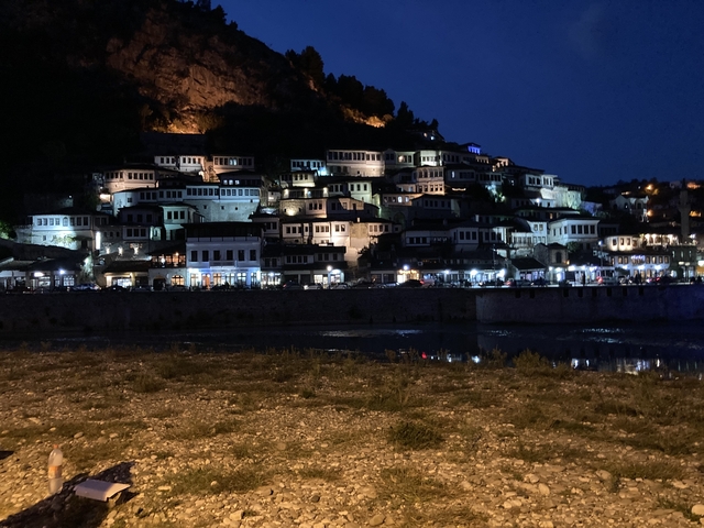City at night with illuminated historic buildings.