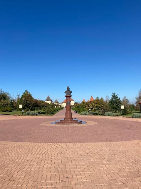       Monument in a courtyard with blue sky.
  