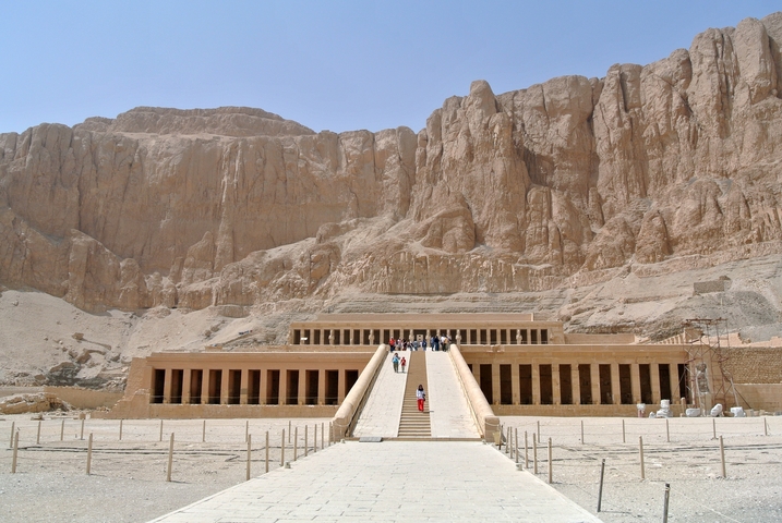 Wide shot of the Temple of Hatshepsut with tourists on the pathway.
