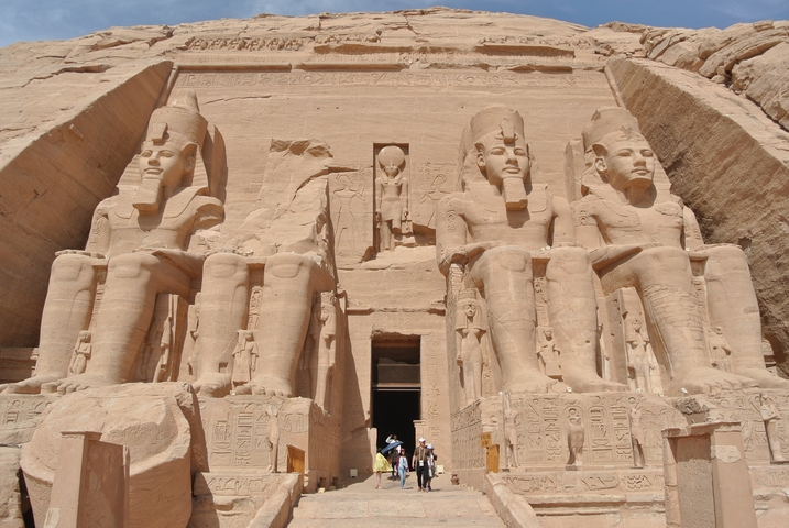 The grand facade of Abu Simbel with tourists at the entrance.