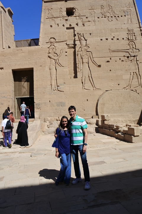 Couple standing in front of a temple entrance with hieroglyphics.