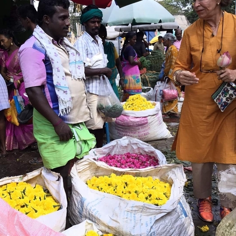       People shopping for vibrant flowers in a market setting.
  