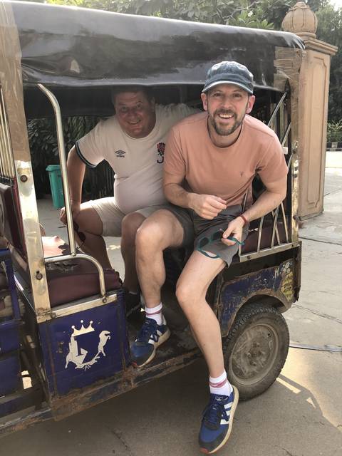       Two people in a tuk-tuk.
  