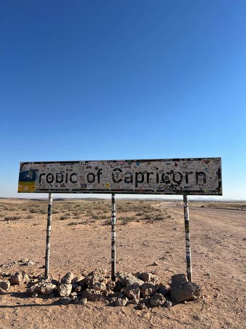 Tropic of Capricorn sign on a desert road.