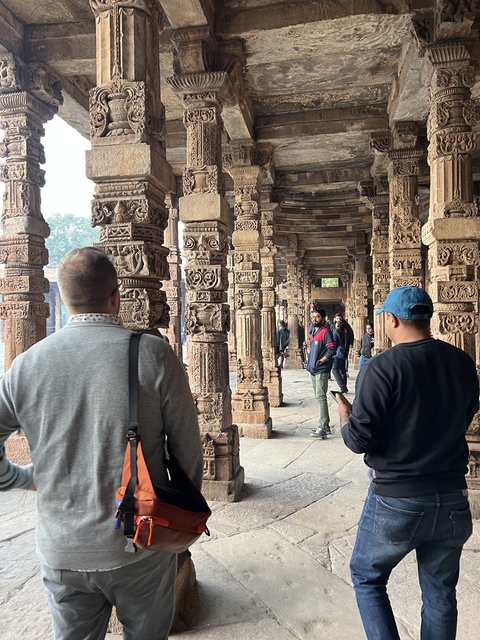 People exploring intricately carved ancient ruins.