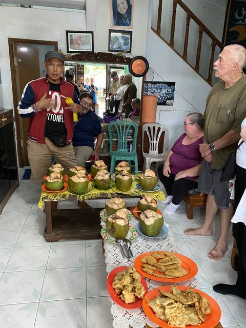       People sitting indoors with traditional food on the table.
  
