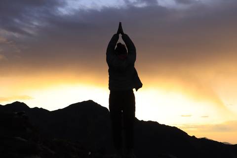 Silhouette of a person practicing yoga at sunset.