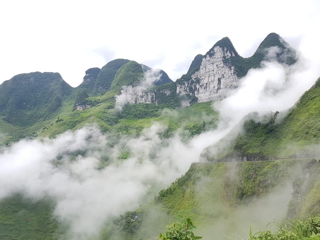       Misty mountains with clouds in a lush green landscape.
  
