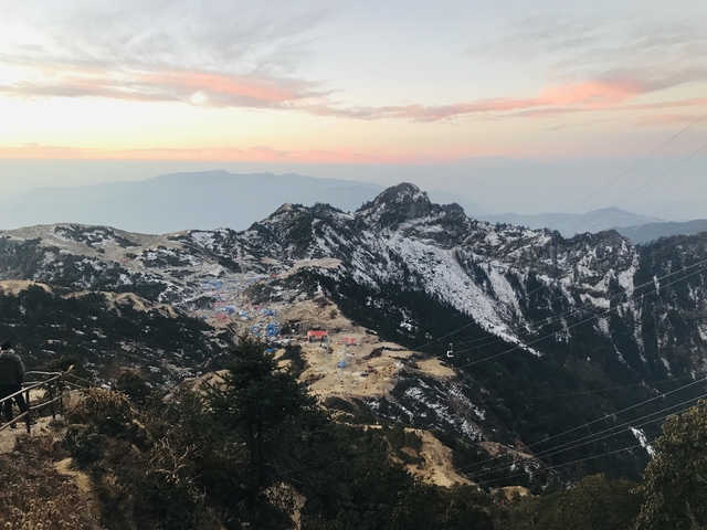       Mountain range at sunset with snow-capped peaks.
  